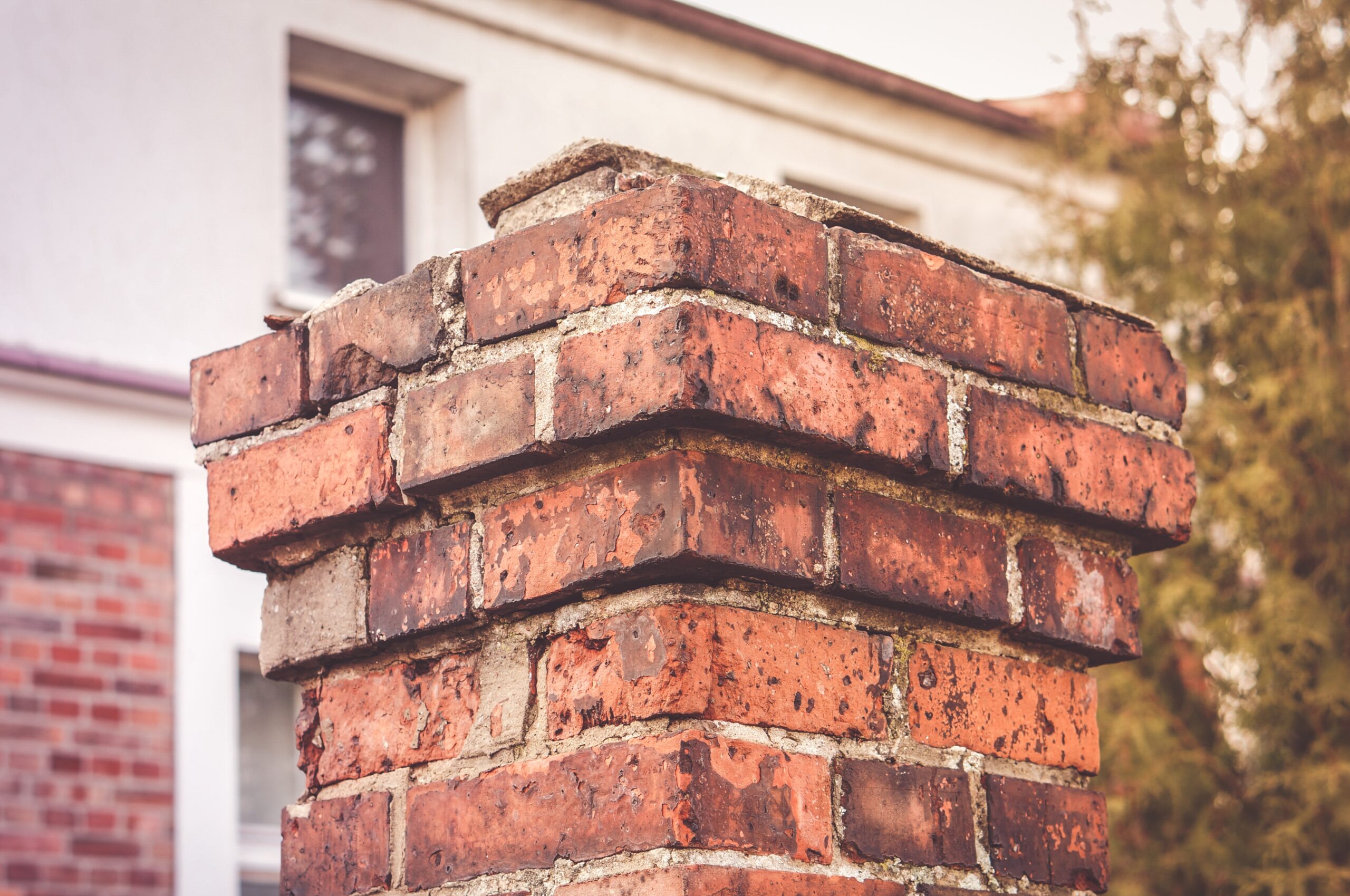 Closeup shot of an old dirty chimney against blurry building