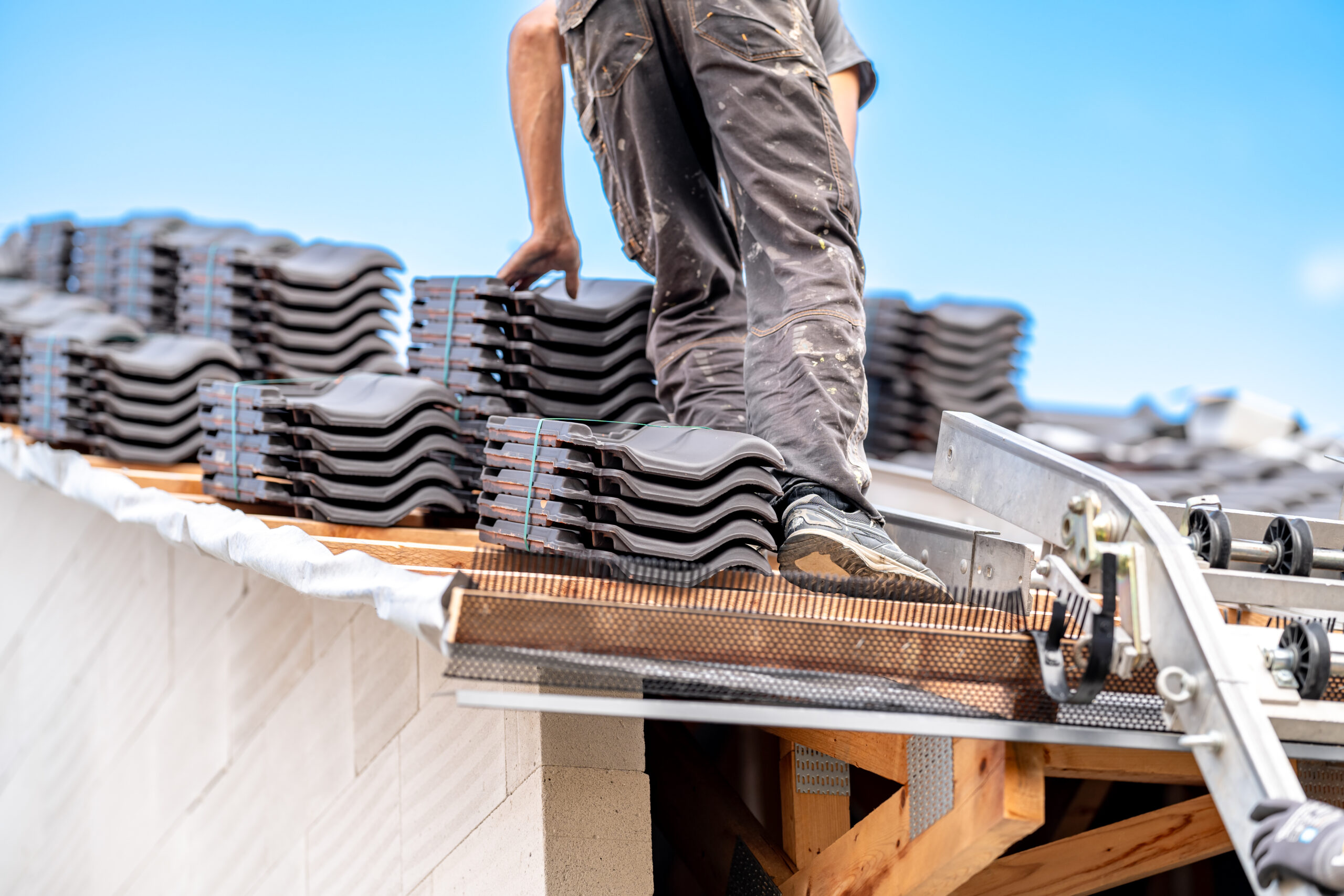 contractor builder laying fired ceramic tiles on the roof