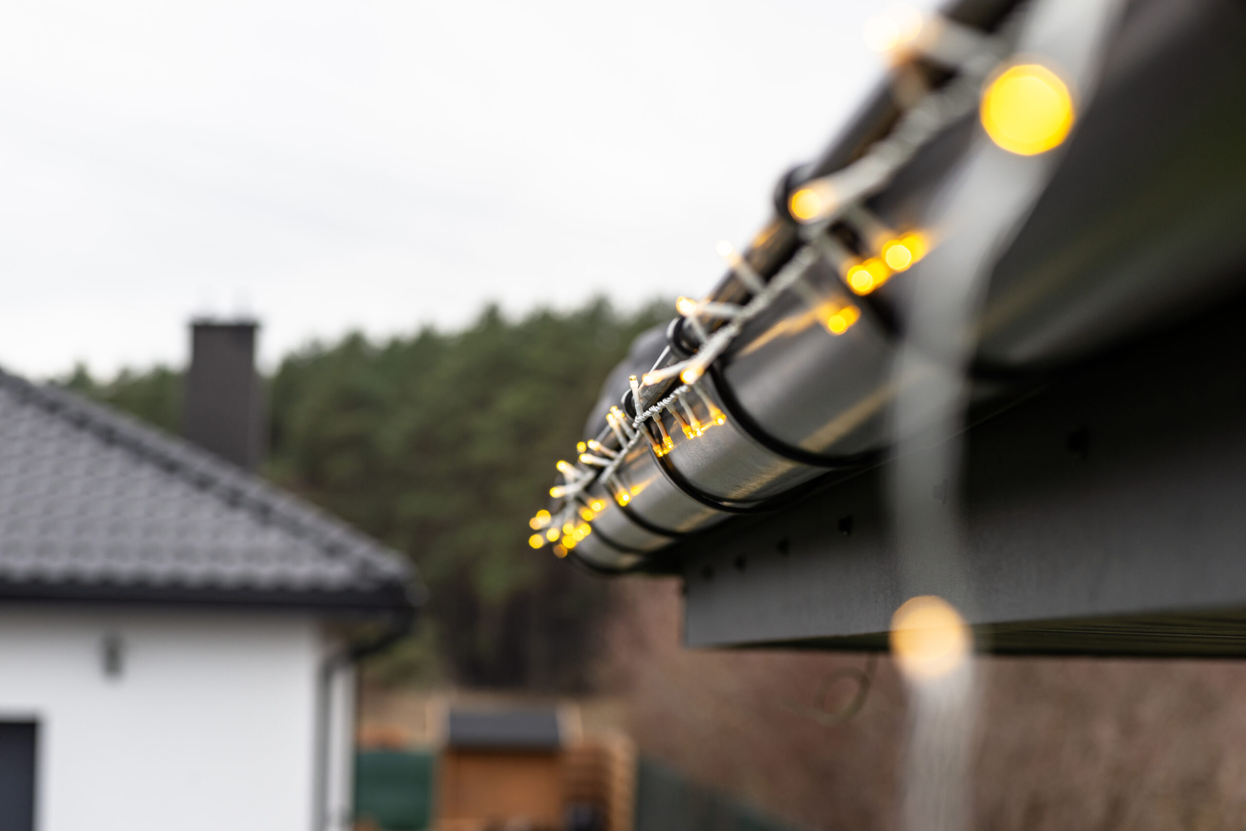 Installing LED lights along the gutter around the house, decorating the house for the holidays.