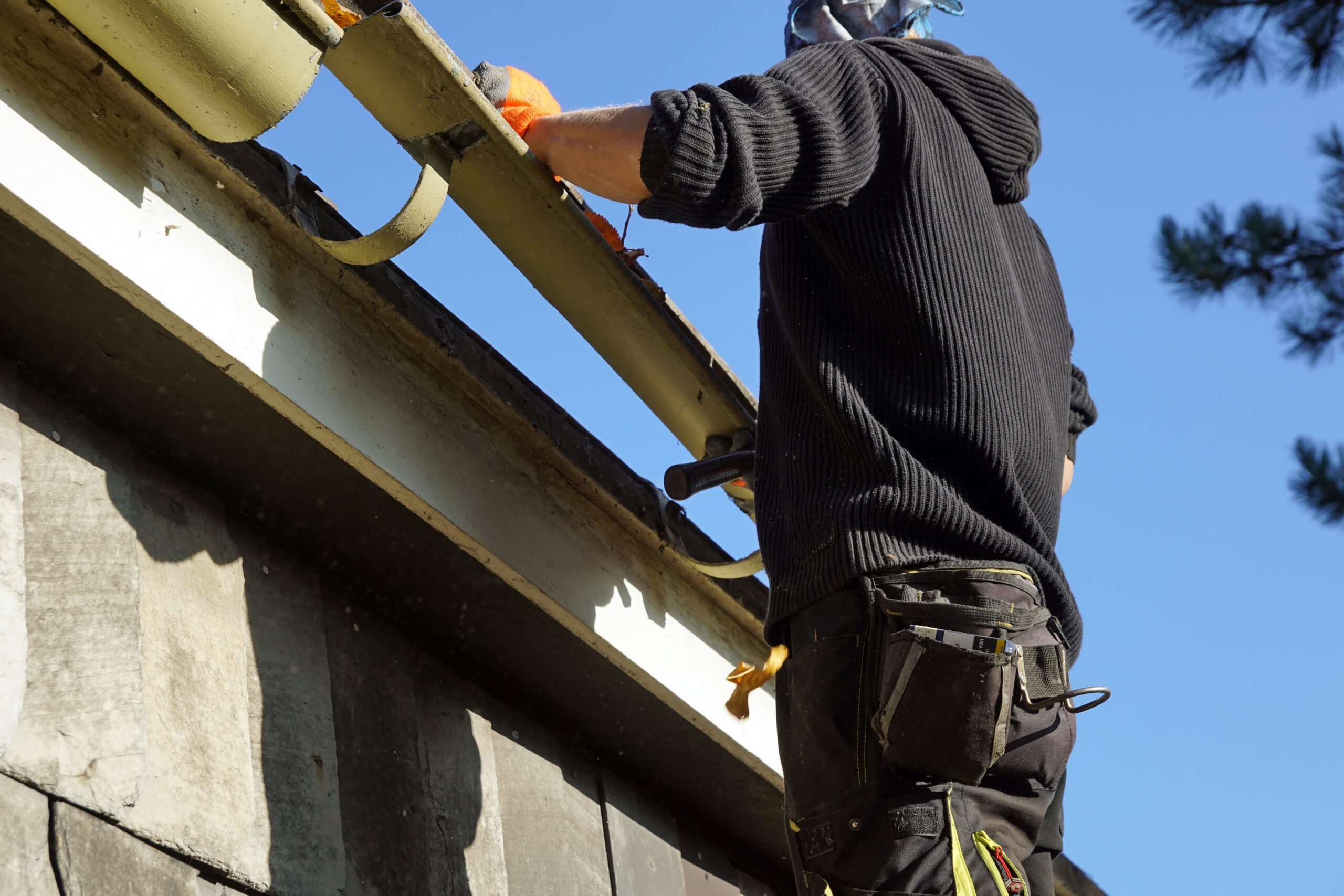 Low angle shot of a construction worker working and fixing a roof