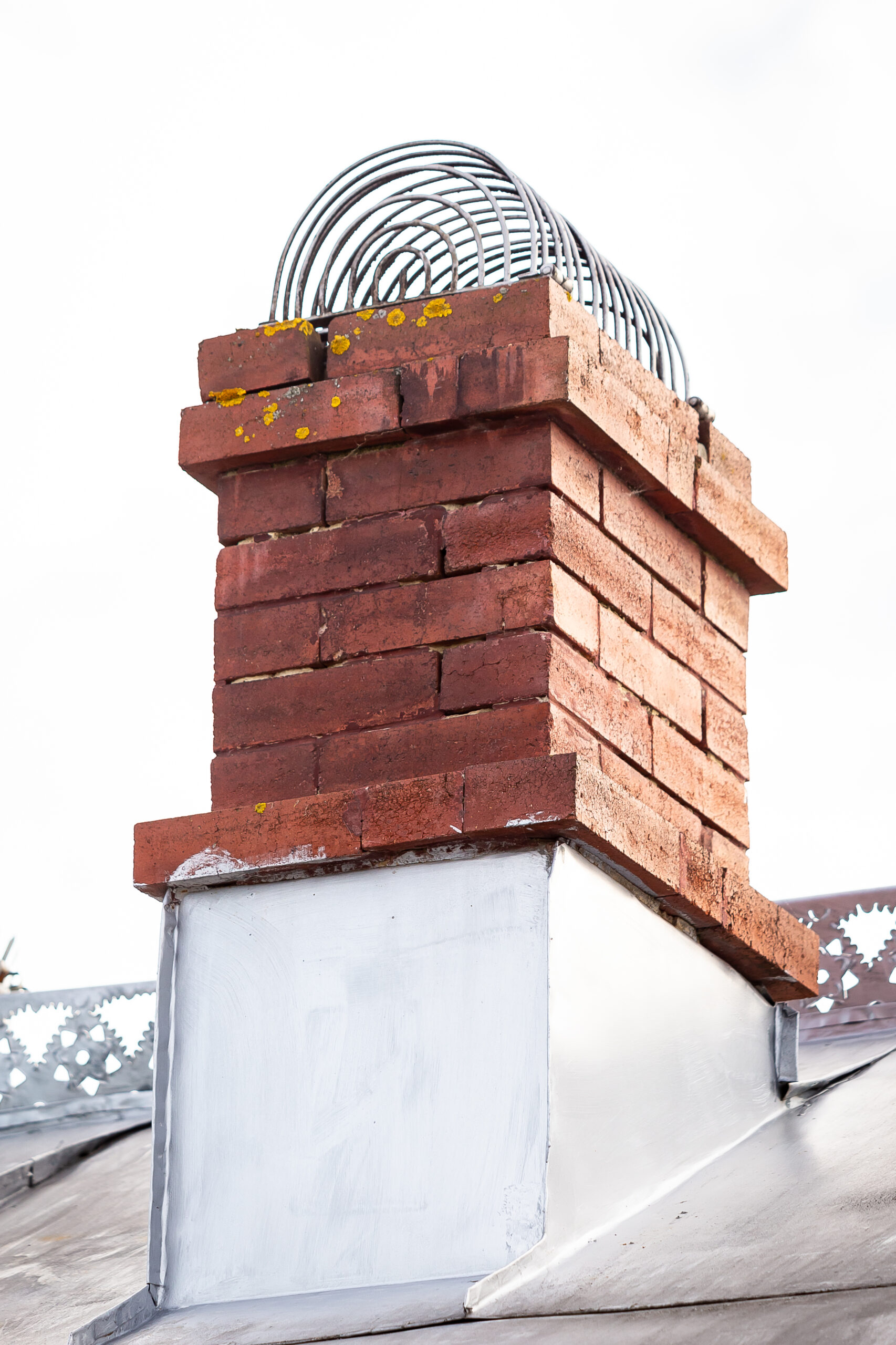 the metal bars are attached to the chimney ventula of a house